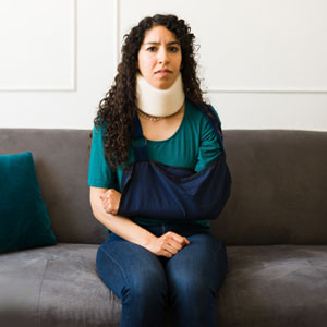 Woman with arm sling and neck brace, symbolizing personal injury claim - Lamb & Frischer Law Firm, LLP